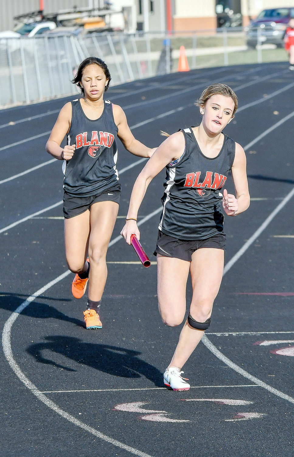 Nolie Finnegan (far right) takes the baton from Piper Marsee for Bland’s Lady Bears during the girls 4200-meter relay in Osage County.